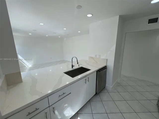 a kitchen with white cabinets and white appliances