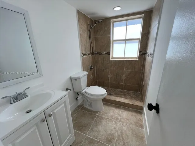 a white toilet sitting next to a bathroom sink and a shower