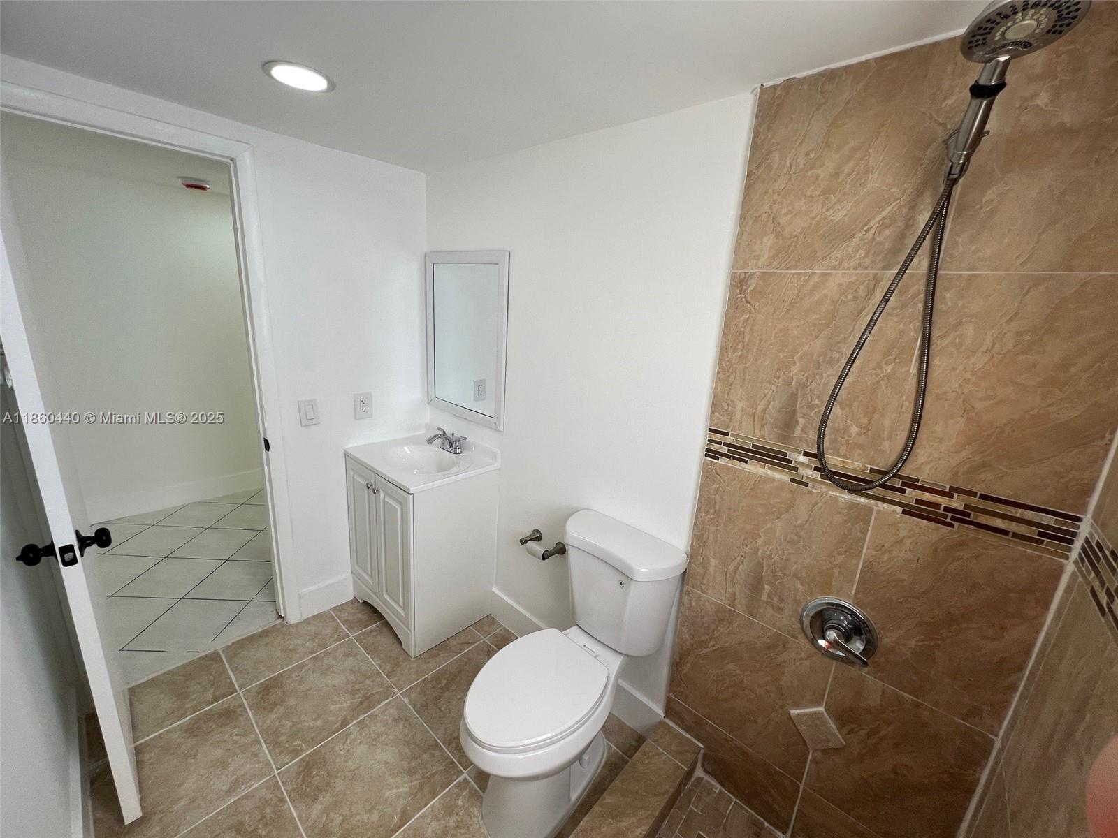 1308 Drexel Avenue, Unit 103 Miami Beach, FL 33139 - Photo 34 of 37 a white toilet sitting next to a bathroom sink and a shower