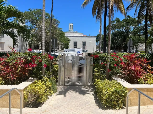 a view of a house with a tree and flower garden