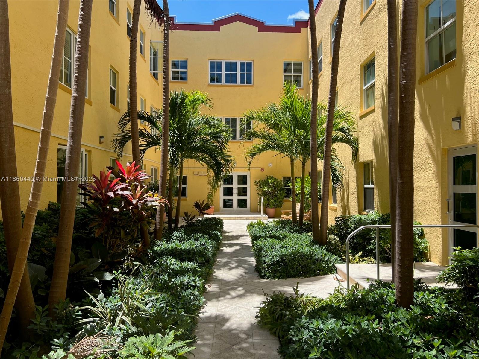1308 Drexel Avenue, Unit 103 Miami Beach, FL 33139 - Photo 8 of 37 a front view of a multi story residential apartment building with a yard