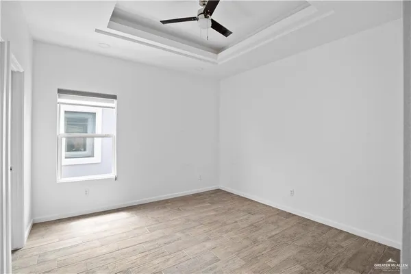 an empty room with a window and ceiling fan