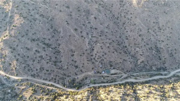 a view of a dry yard with mountains in the background