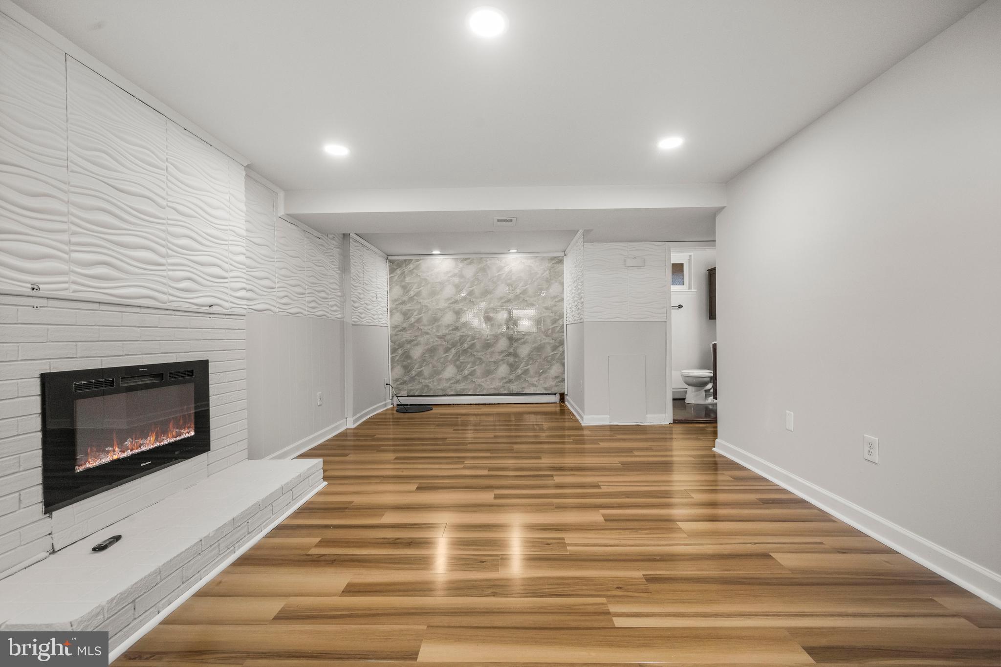 13411 Kerrydale Road Woodbridge, VA 22193 - Photo 27 of 44 a view of an empty room with wooden floor and a fireplace