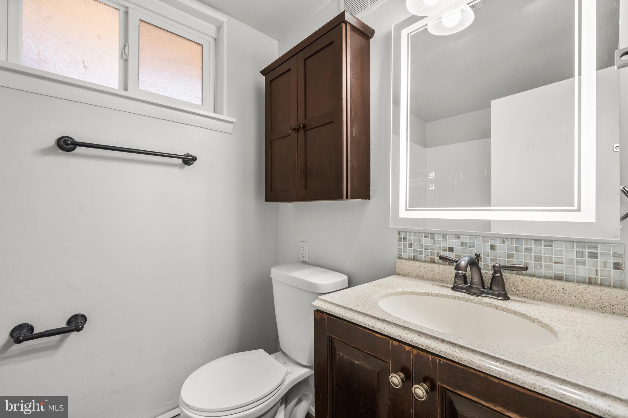 13411 Kerrydale Road Woodbridge, VA 22193 - Photo 31 of 44 a bathroom with a granite countertop sink a toilet and a mirror