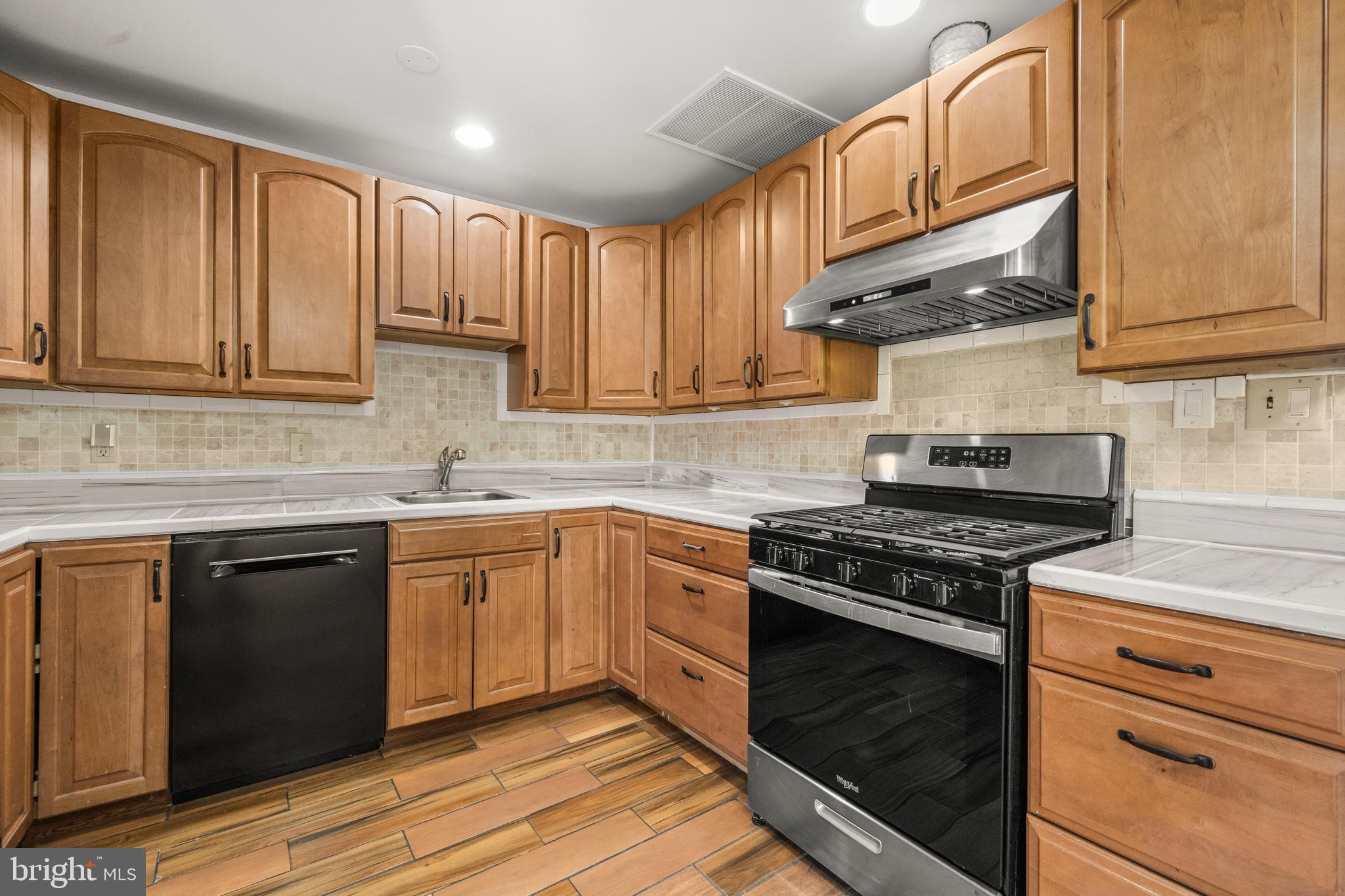 13411 Kerrydale Road Woodbridge, VA 22193 - Photo 8 of 44 a kitchen with stainless steel appliances granite countertop a stove a sink dishwasher and cabinets with wooden floor