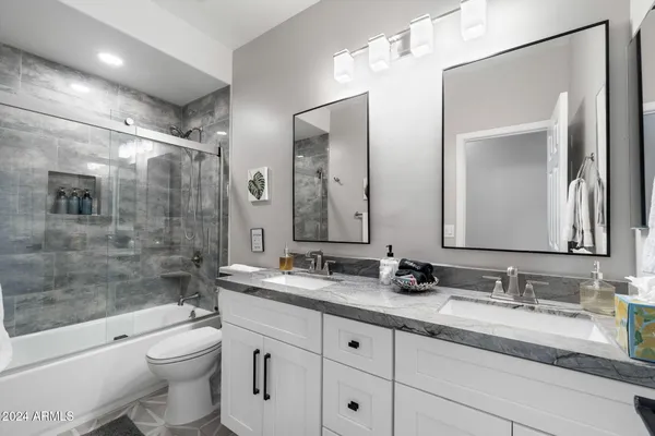 a bathroom with double vanity sink and two mirror