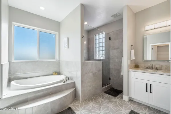 a spacious bathroom with a granite countertop sink mirror and shower