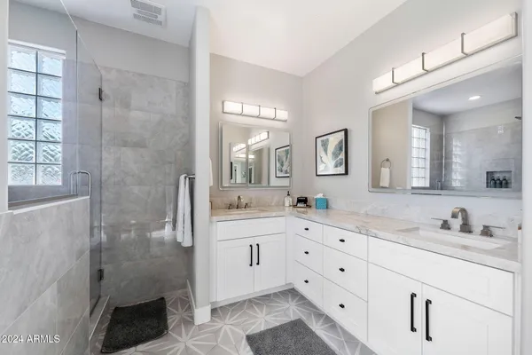 a spacious bedroom with a large bed and a chandelier