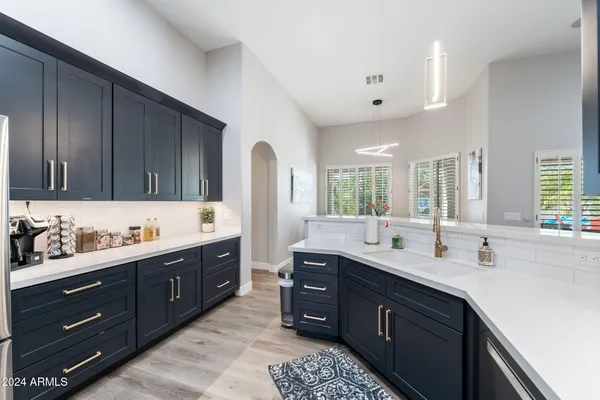 a kitchen with granite countertop a sink stove and refrigerator