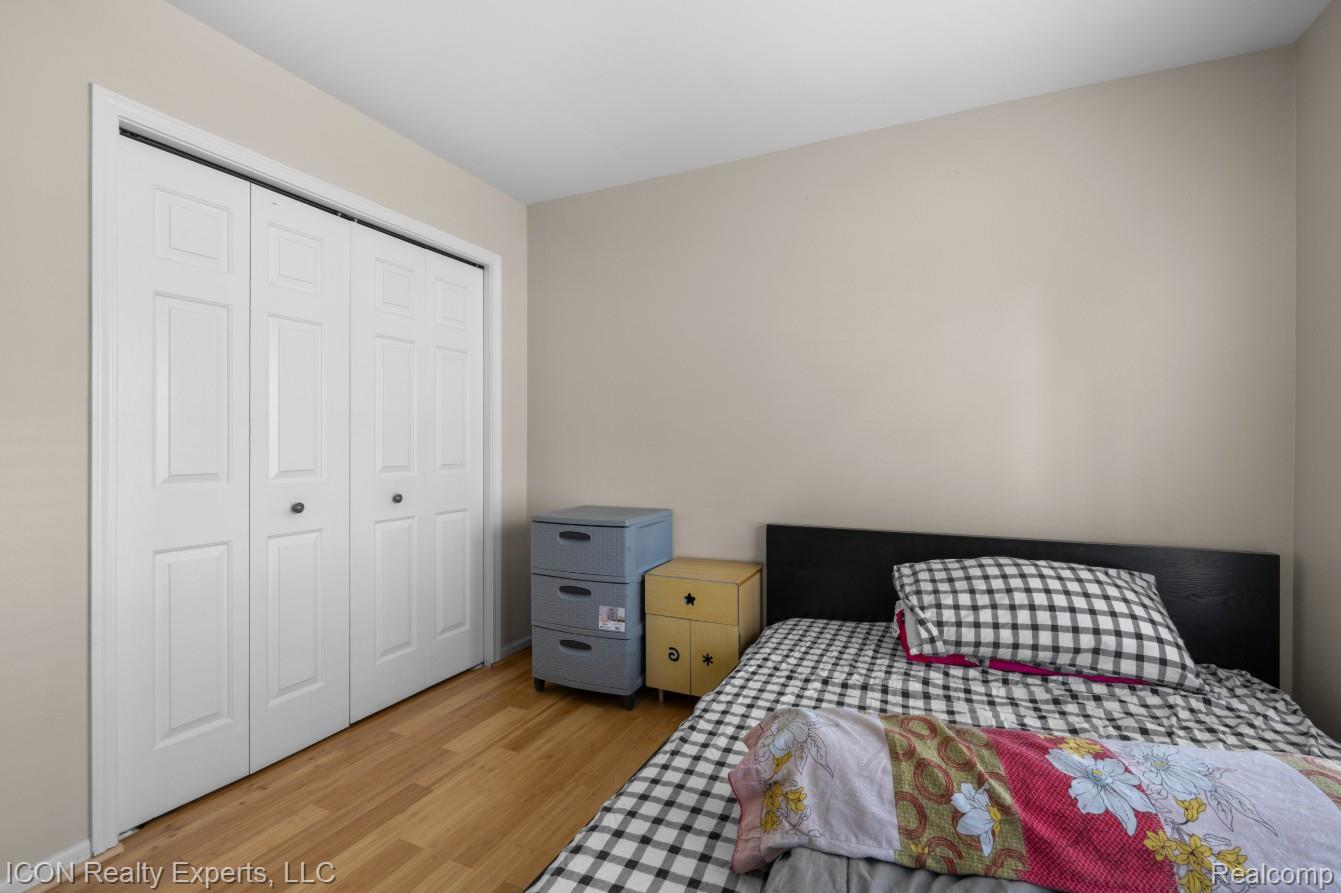 531 Cherry Grove Road Canton, MI 48188 - Photo 19 of 30 White bi-fold closet doors with black hardware, wood-finish flooring, and neutral wall paint