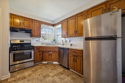 a kitchen with stainless steel appliances granite countertop a sink stove and cabinets