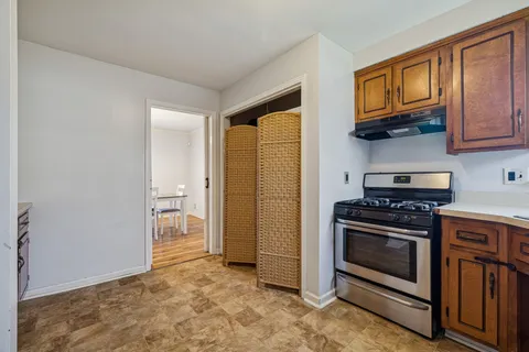a dining room with wooden floor a chandelier a wooden table and chairs