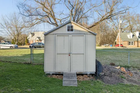 a front view of a house with a yard and trees