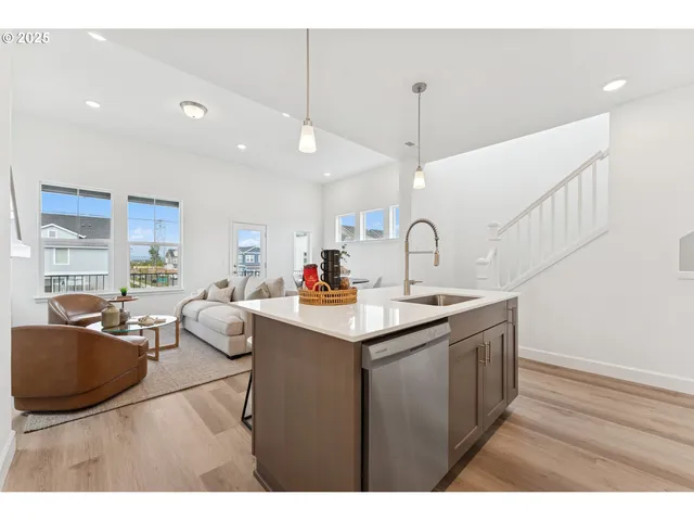 a kitchen with stainless steel appliances granite countertop a sink and a wooden floor
