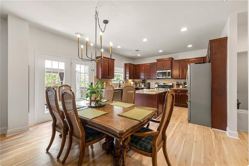 4970 Creekside Lane Powder Springs, GA 30127 - Photo 12 of 45 a dining room with stainless steel appliances kitchen island granite countertop a dining table chairs and a refrigerator