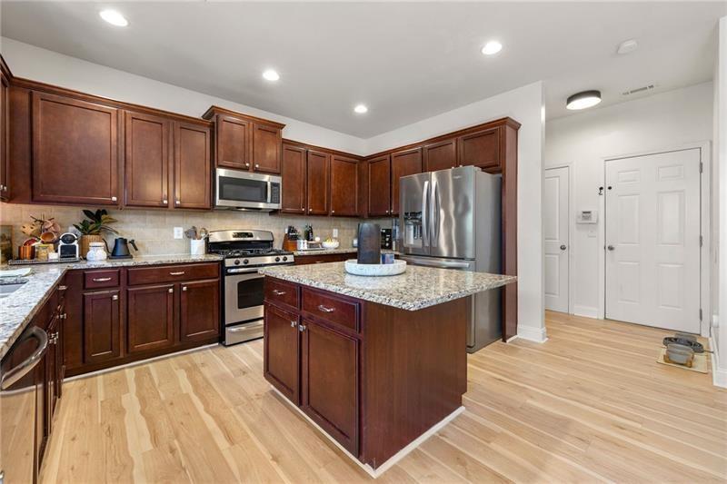 4970 Creekside Lane Powder Springs, GA 30127 - Photo 14 of 45 a kitchen with stainless steel appliances granite countertop a stove refrigerator sink and cabinets