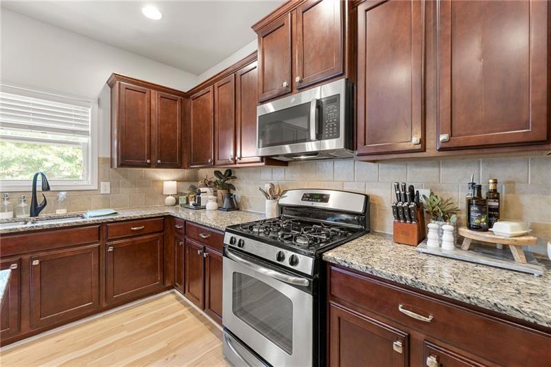4970 Creekside Lane Powder Springs, GA 30127 - Photo 15 of 45 a kitchen with stainless steel appliances granite countertop a sink stove and microwave
