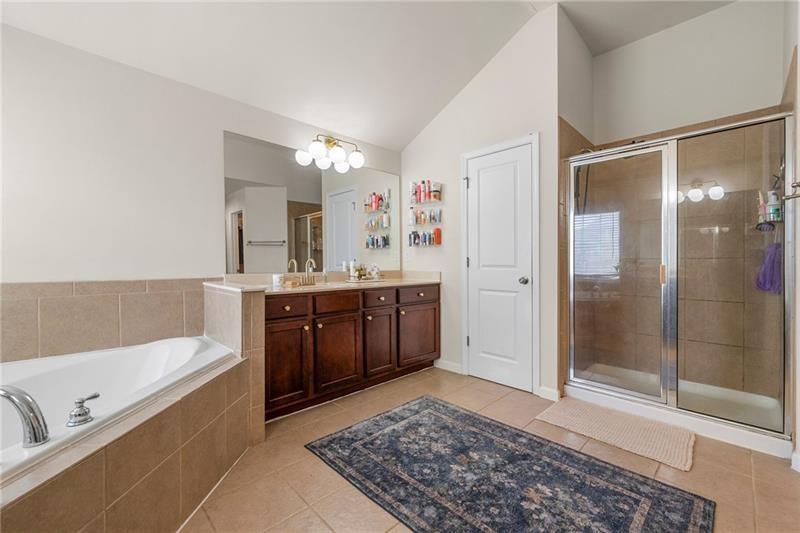 4970 Creekside Lane Powder Springs, GA 30127 - Photo 27 of 45 a bathroom with a tub a sink and a mirror