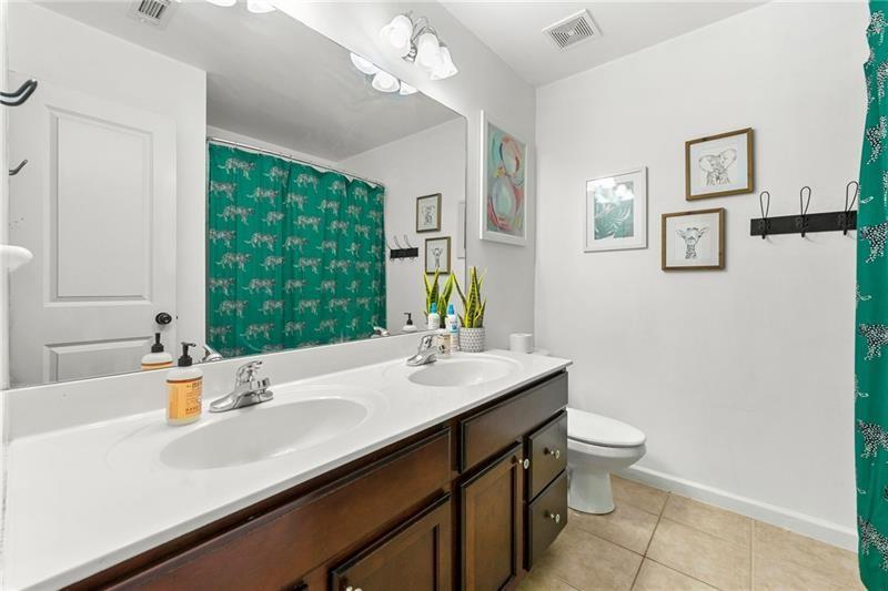 4970 Creekside Lane Powder Springs, GA 30127 - Photo 27 of 45 a bathroom with a sink a large mirror and a toilet