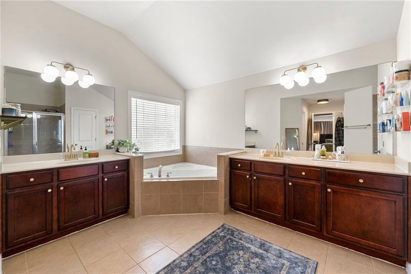 4970 Creekside Lane Powder Springs, GA 30127 - Photo 30 of 45 a spacious bathroom with a tub a double vanity sink and a window