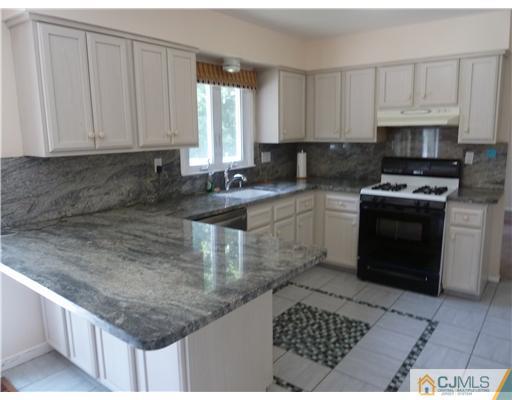 4 Paddock Court Edison, NJ 08820 - Photo 4 of 23 a kitchen with stainless steel appliances granite countertop a sink stove and cabinets