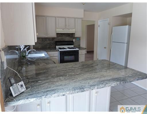 4 Paddock Court Edison, NJ 08820 - Photo 5 of 23 a kitchen with kitchen island sink stove and refrigerator