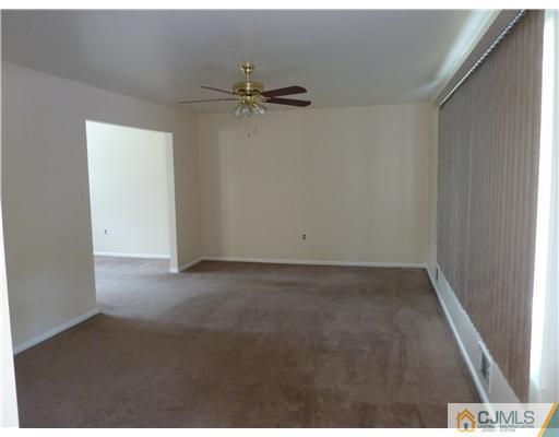 4 Paddock Court Edison, NJ 08820 - Photo 9 of 23 an empty room with a ceiling fan and carpet