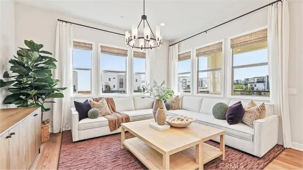a living room with furniture large window and wooden floor