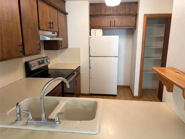 an empty room with wooden floor fireplace and windows