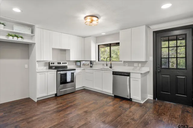 a kitchen with granite countertop white cabinets and white appliances