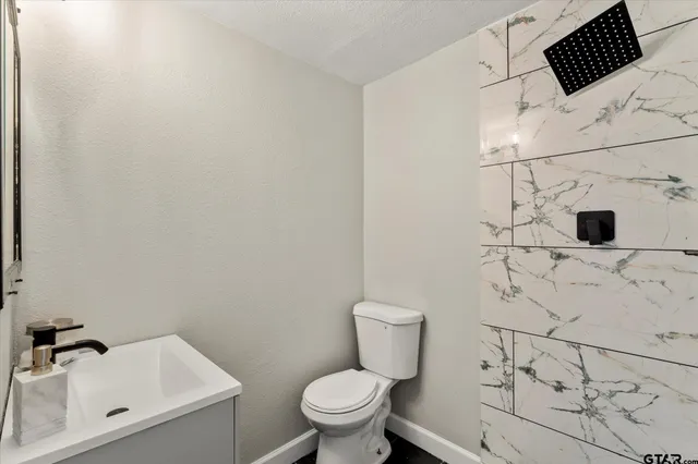a white toilet sitting next to a bathroom sink