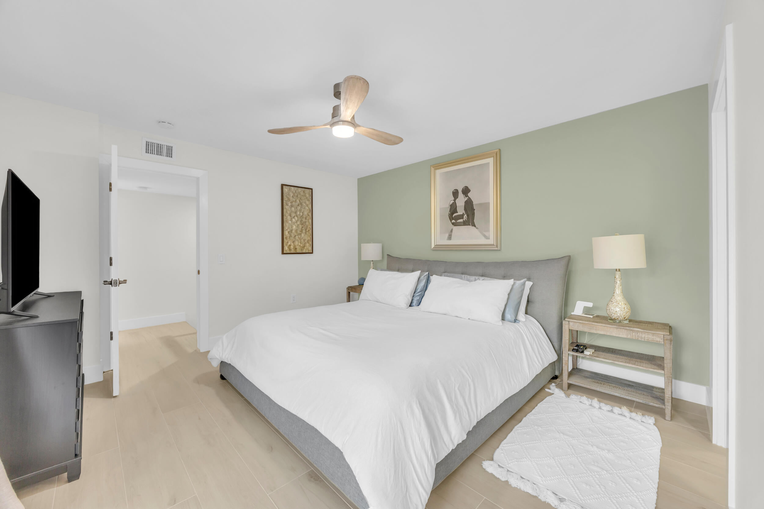 1208 12th Court Jupiter, FL 33477 - Photo 17 of 31 a spacious bedroom with a bed and a lamp