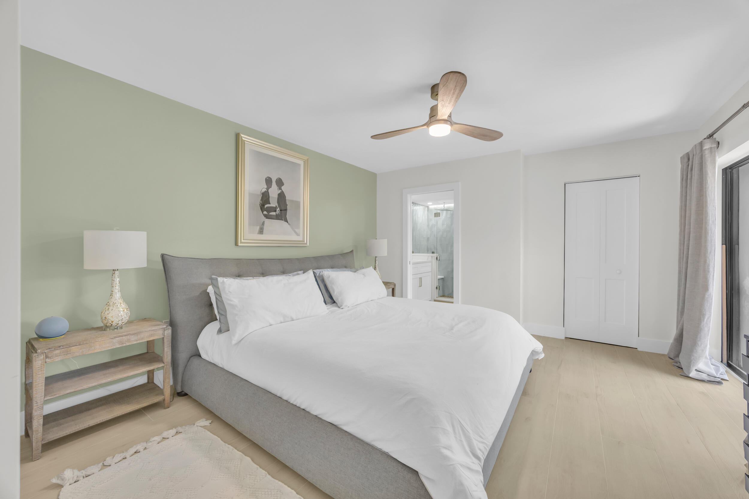 1208 12th Court Jupiter, FL 33477 - Photo 19 of 31 a spacious bedroom with a bed and a painting on the wall