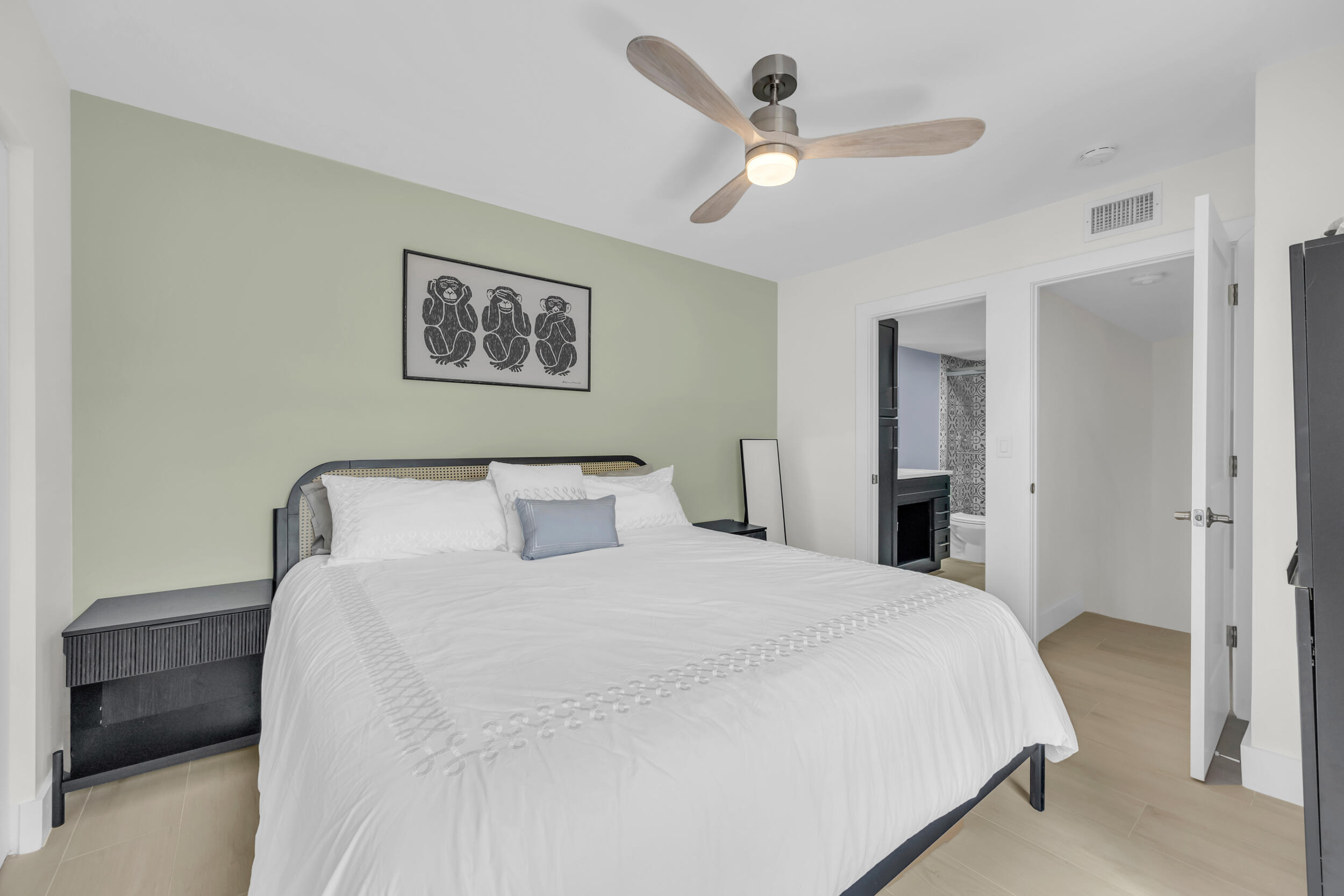 1208 12th Court Jupiter, FL 33477 - Photo 23 of 31 a bedroom with a bed and a painting on the wall