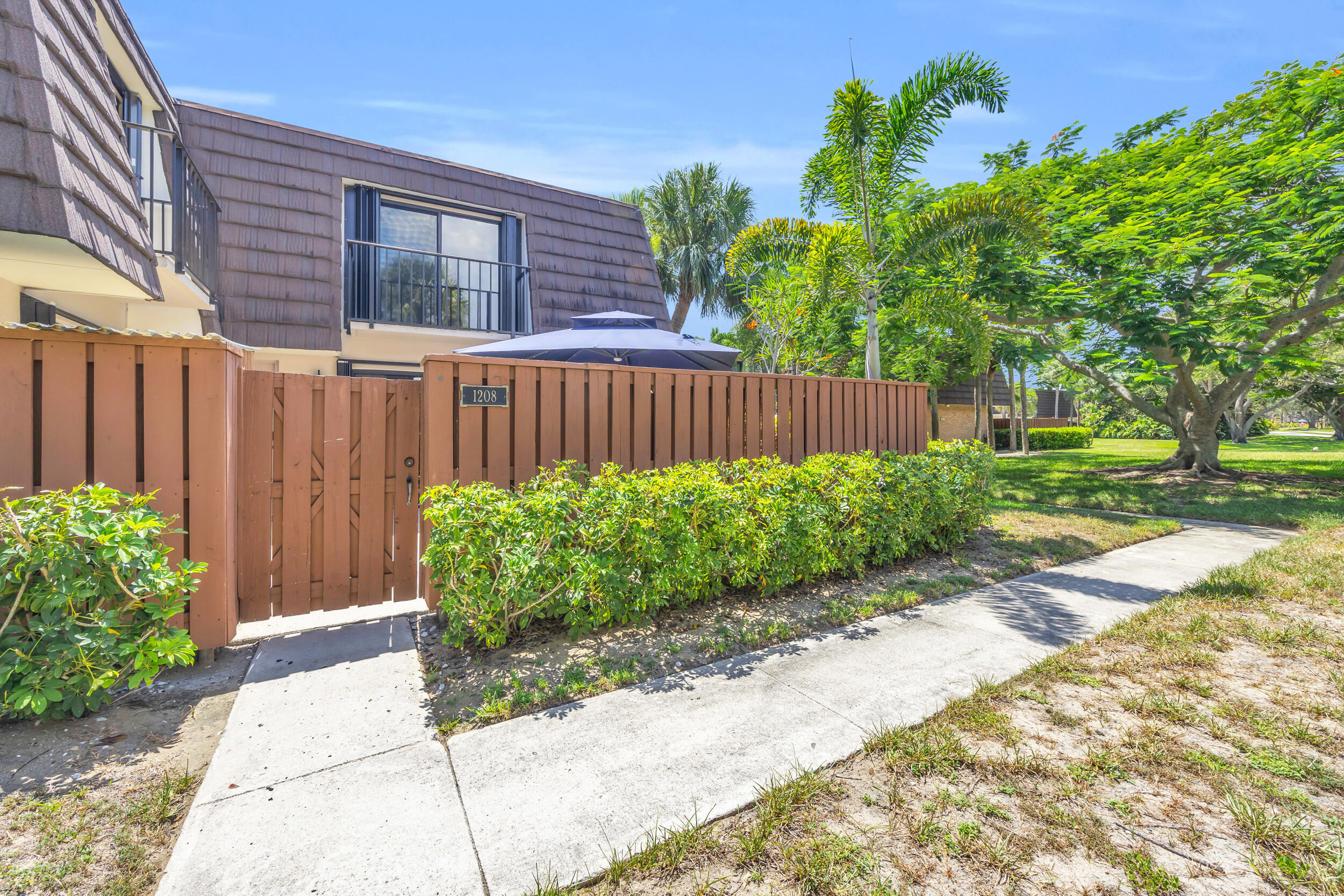 1208 12th Court Jupiter, FL 33477 - Photo 29 of 31 a view of a backyard with potted plants and wooden fence