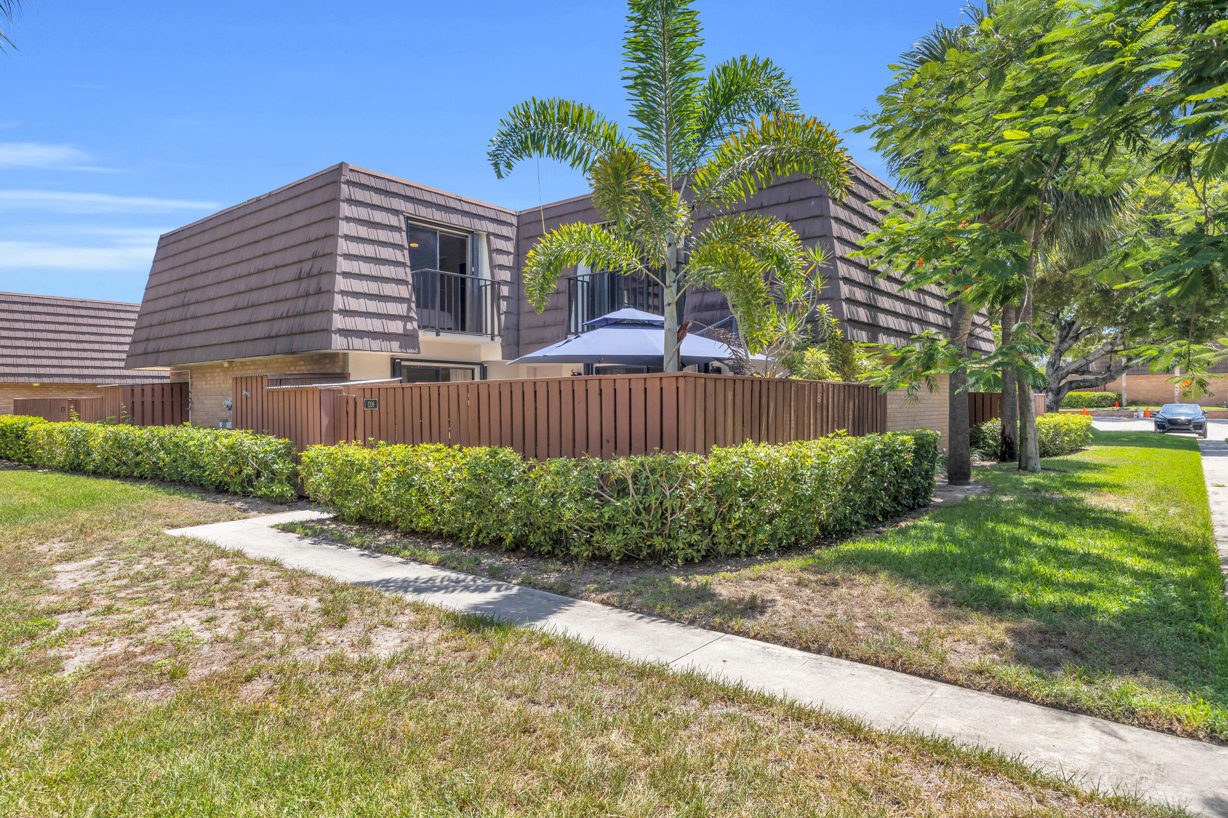 1208 12th Court Jupiter, FL 33477 - Photo 30 of 31 a front view of a house with a yard and a garage