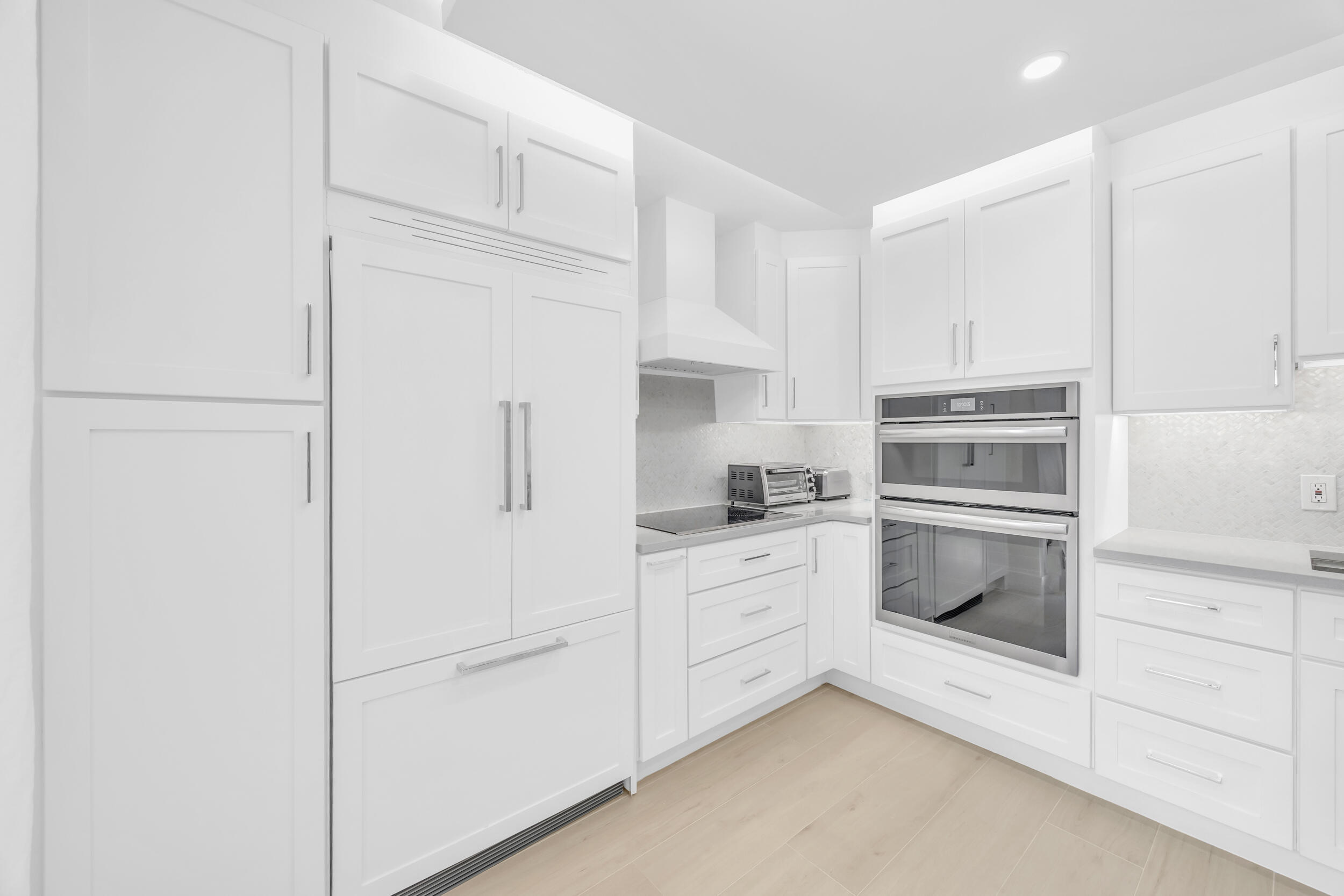 1208 12th Court Jupiter, FL 33477 - Photo 3 of 31 a kitchen with white cabinets and white appliances