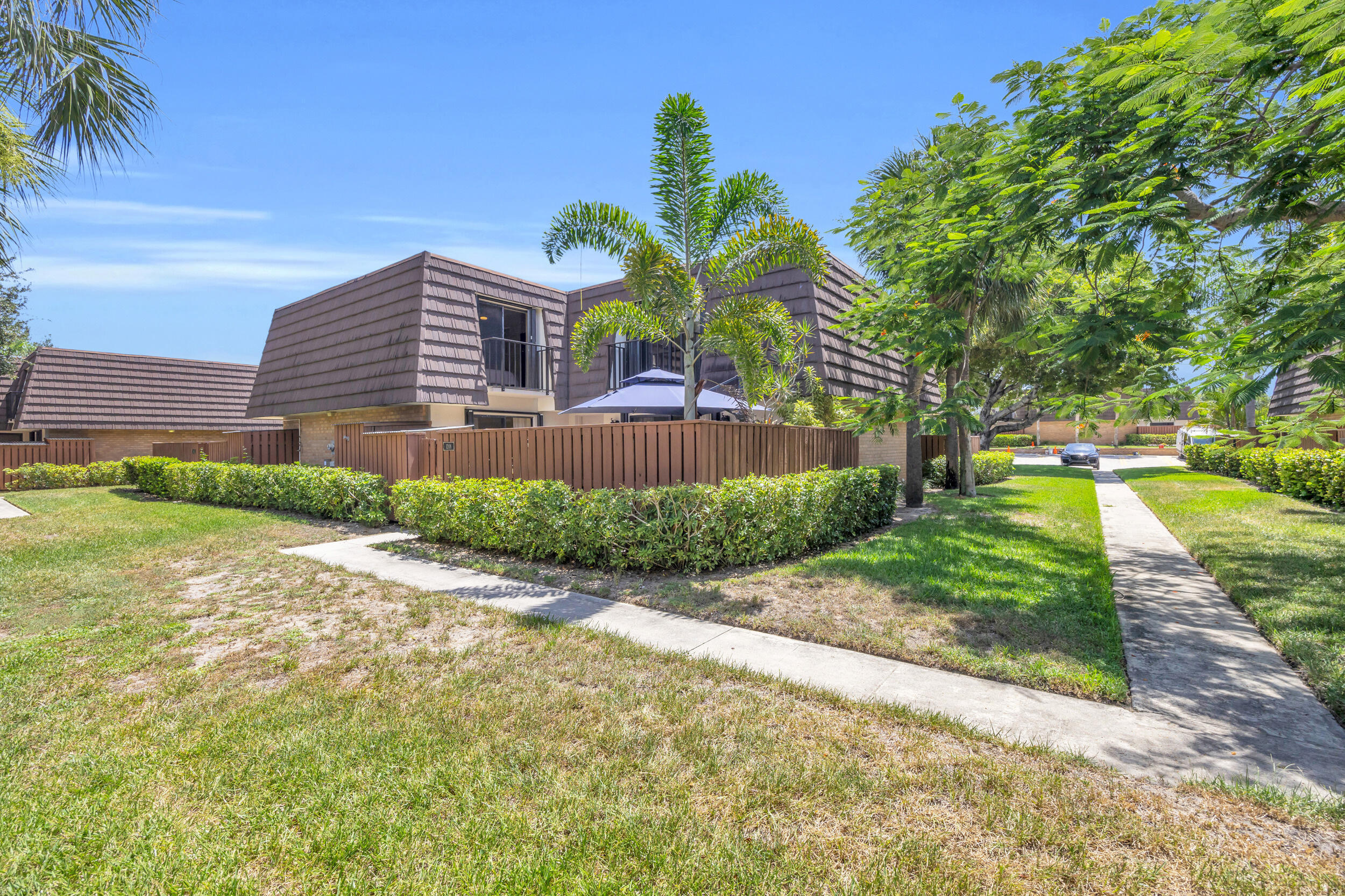 1208 12th Court Jupiter, FL 33477 - Photo 31 of 31 a front view of a house with a yard and a garage