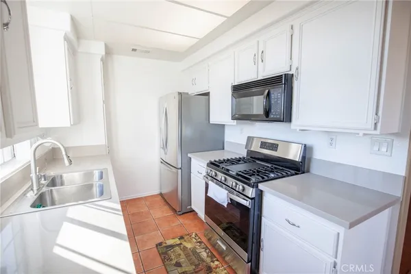 a kitchen with stainless steel appliances granite countertop a stove refrigerator and a microwave