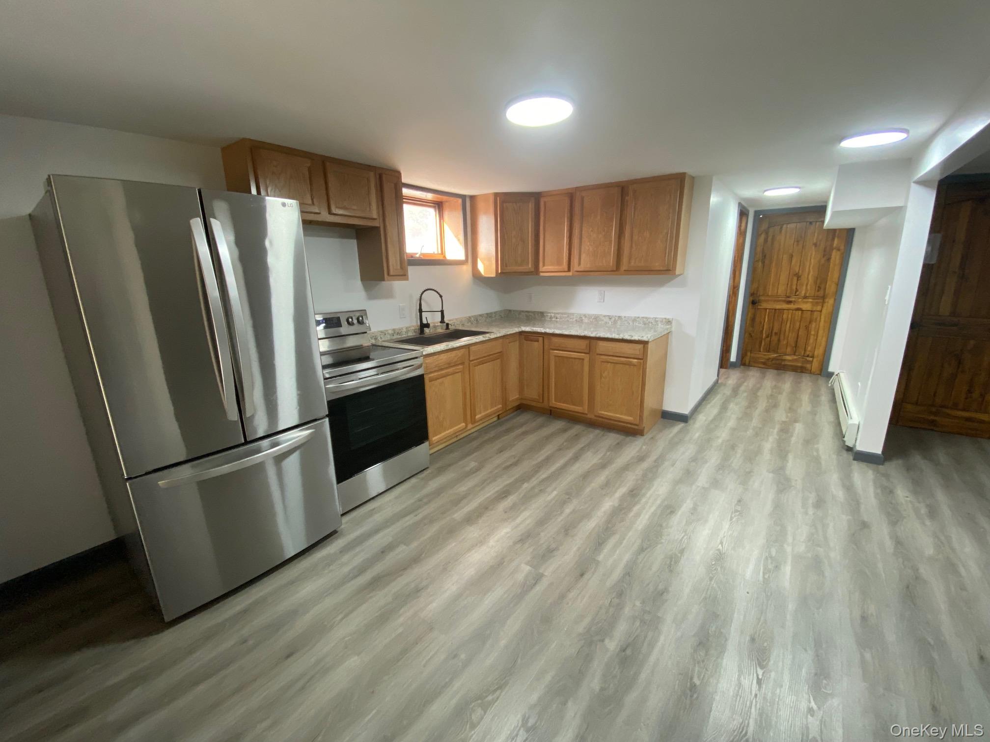 315 Upper Road, Unit LOWR Middletown, NY 10940 - Photo 2 of 9 Kitchen with appliances with stainless steel finishes, light hardwood / wood-style flooring, baseboard heating, and sink