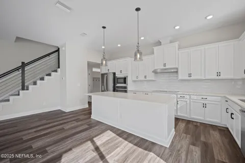 a large white kitchen with cabinets
