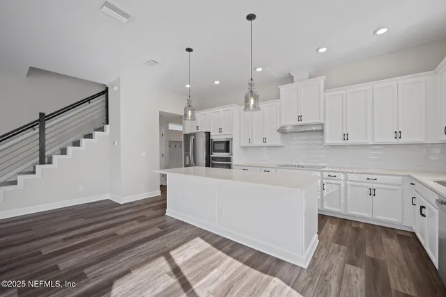 a large white kitchen with cabinets