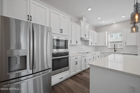 a kitchen with stainless steel appliances a refrigerator sink and microwave