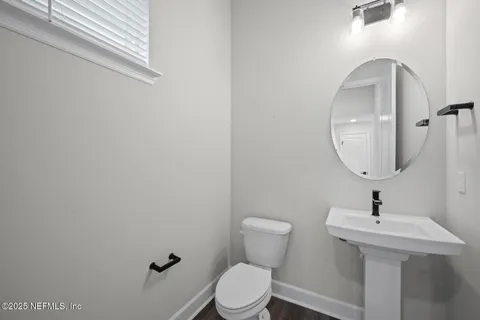 a bathroom with a toilet a sink and mirror