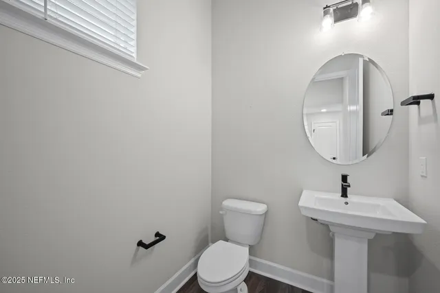 a bathroom with a toilet a sink and mirror