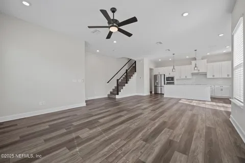 a view of a room with wooden floor and ceiling fan