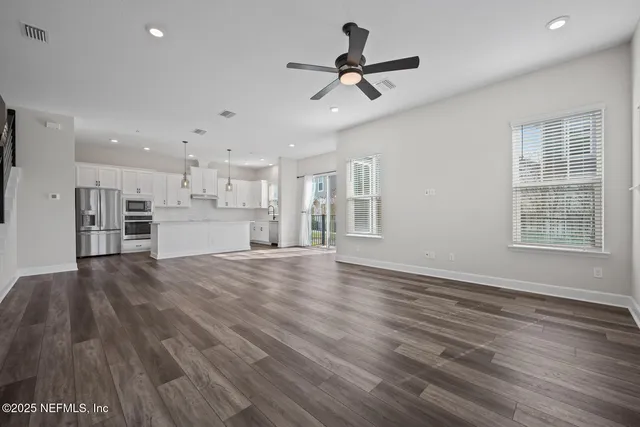a view of empty room with wooden floor and window