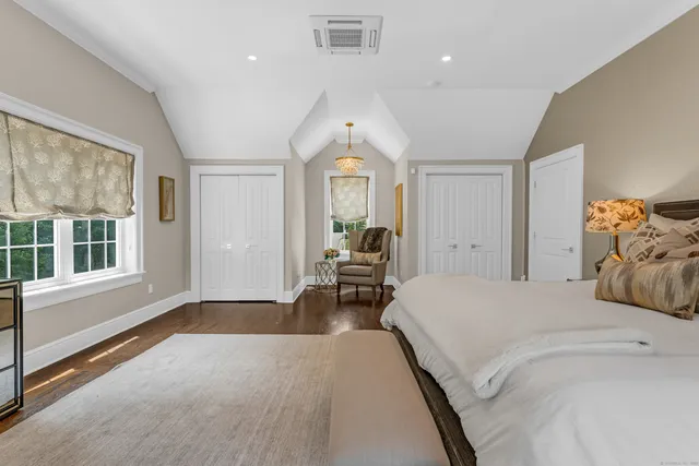 a spacious bedroom with a large bed and wooden floor