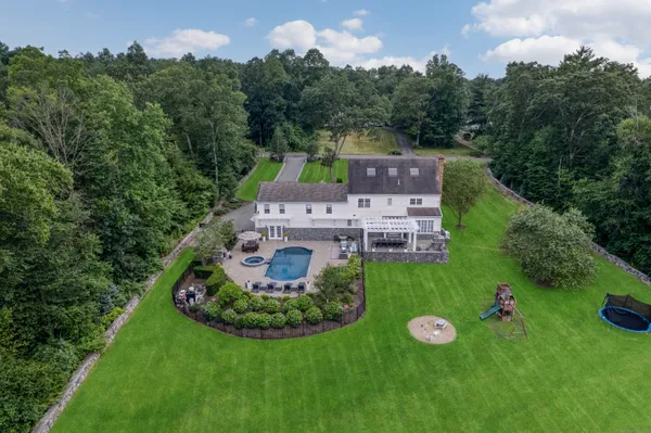 an aerial view of a house with yard swimming pool and outdoor seating
